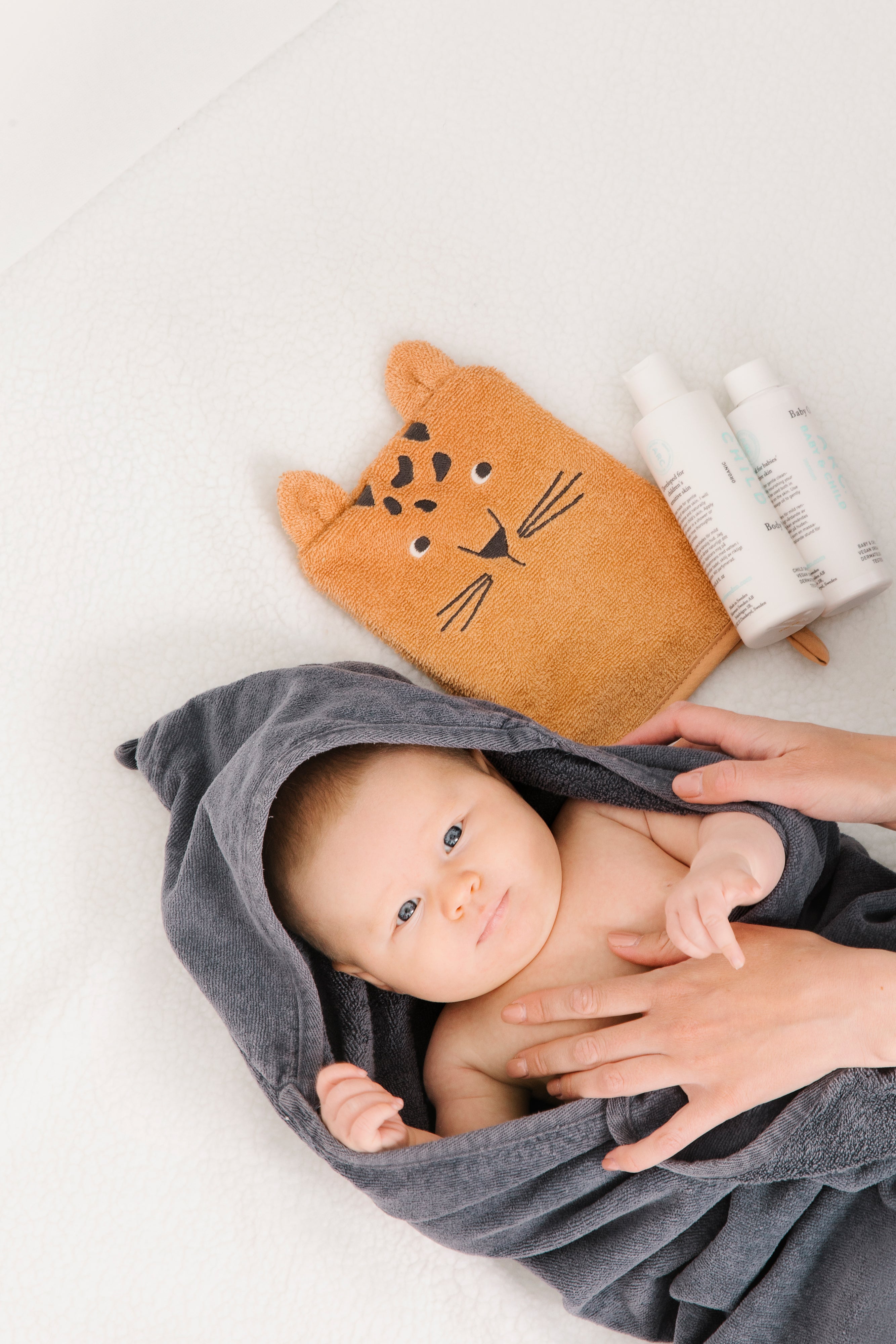Bebis i handduk bredvid ARC produkter